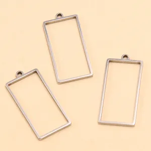 Vue détaillée de pendentifs rectangulaires en acier inoxydable pour création de bijoux DIY.