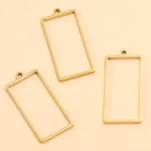Détail macro de trois cadres de pendentif rectangulaires en acier inoxydable doré pour bijoux.