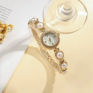 Elegant gold-toned women's quartz watch featuring a luxury pearl bracelet strap detail.