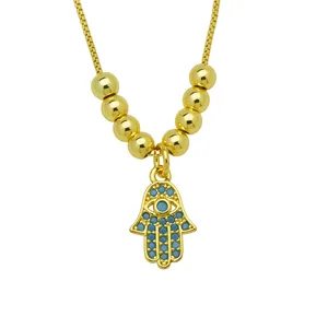 Detail of gold-plated Hamsa hand pendant necklace with blue zircon accents