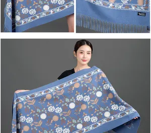 Close-up detail of blue scarf with snowflake floral embroidery and soft fringes