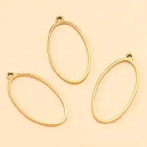 Gros plan de trois montures de pendentifs ovales en acier doré pour bijoux DIY.
