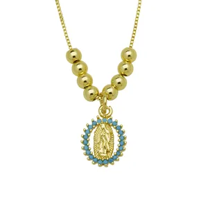 Close-up detail of a gold-plated Virgin Mary pendant surrounded by turquoise beads