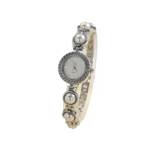 Elegant women's quartz watch featuring a large pearl bracelet and textured silver-tone case