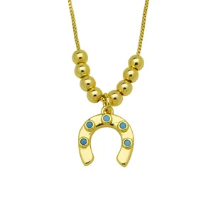 Detailed view of the 18K gold plated horseshoe pendant with turquoise accents