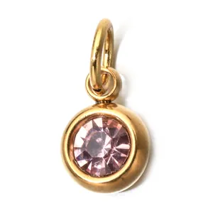Close-up of a golden stainless steel pendant featuring a faceted pink birthstone.