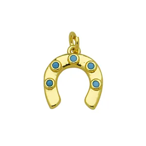Detailed view of golden horseshoe pendant with blue turquoise-style inlays.