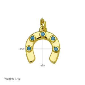 Detailed view of gold-plated horseshoe pendant with blue stones and size markings