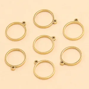 Gros plan de breloques géométriques circulaires en acier doré pour la création de bijoux