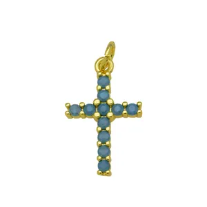 Macro view of a gold-plated cross pendant decorated with blue round cubic zirconia