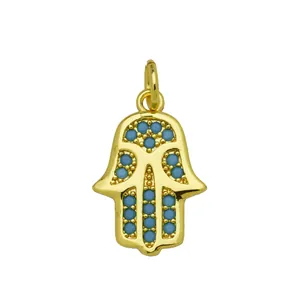 Macro view of gold-plated Hamsa Hand pendant with blue zircons for jewelry making