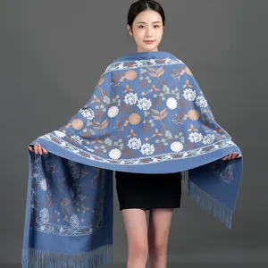 Elegant blue floral embroidered winter shawl scarf with fringes worn by a model.
