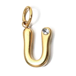 Detail view of a gold stainless steel letter U pendant featuring a clear birthstone