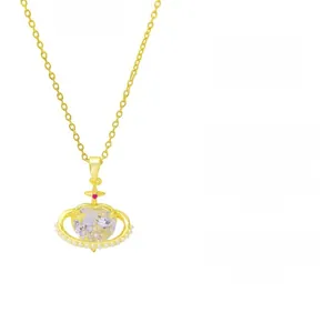 Detailed view of gold-tone heart necklace featuring crystal pendant and pearl accents
