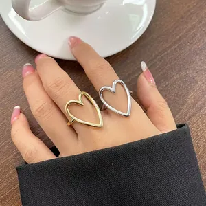 Macro detail of minimalist gold and silver hollow heart-shaped adjustable open rings