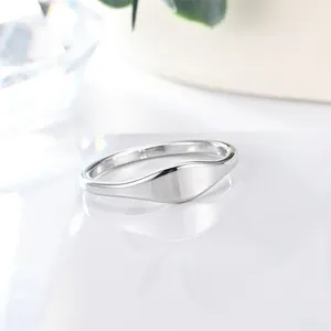 Close-up of minimalist polished stainless steel ring with smooth silver finish.