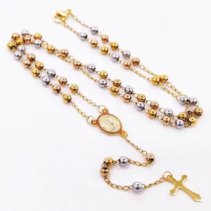 Detailed macro view of tri-color stainless steel rosary beads with a cross pendant