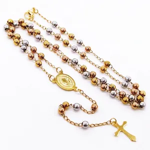 Detail of tri-color stainless steel rosary necklace with cross and medallion