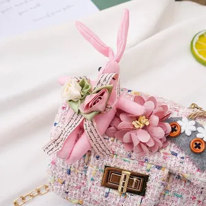 Close-up detail of cute pink tweed children's crossbody bag with rabbit and flower accents