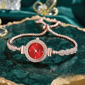 Vista detallada de un elegante reloj de mujer con esfera roja y pulsera de strass brillante