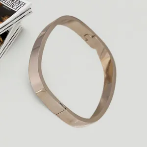 Vista dettagliata di un bracciale rigido quadrato minimalista in oro rosa con finitura metallica