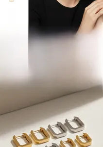 Detaillierte Nahaufnahme von minimalistischen rechteckigen Creolen in Gold und Silber