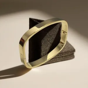 Primo piano di un bracciale rigido quadrato dorato con una finitura lucida a specchio