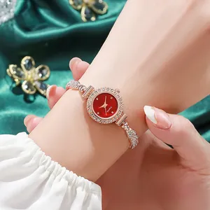 Vista detallada de un elegante reloj de diamantes de oro rosa con esfera roja en la muñeca