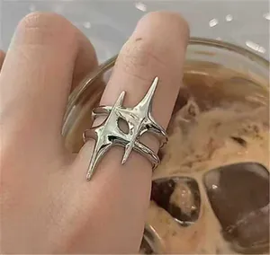 Detailed view of silver irregular starburst ring on finger in a lifestyle setting.