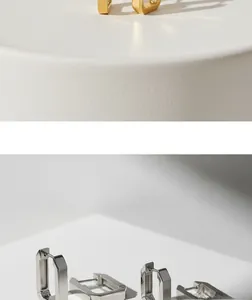 Minimalistische rechteckige Metall-Creolen in Gold und Silber auf weißer strukturierter Fläche