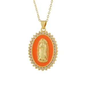Detailed macro shot of vintage gold Virgin Mary pendant with orange enamel and stones.