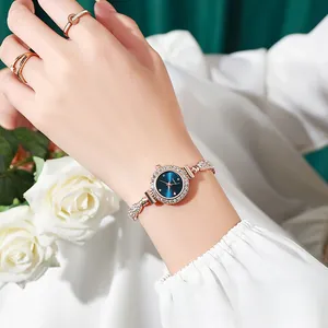 Elegante reloj de cuarzo para mujer en oro rosa con esfera azul pequeña y brazalete joya.