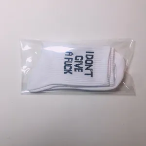 Detailed view of white slogan cotton socks in clear plastic packaging for retail sales.