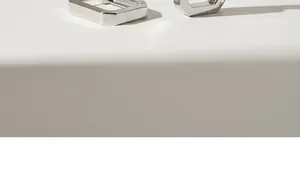 Nahaufnahme minimalistischer rechteckiger Silberohrringe mit glänzendem Finish