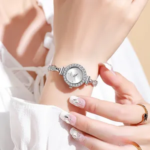 Primer plano de elegante reloj de cuarzo para mujer con bisel de diamantes.