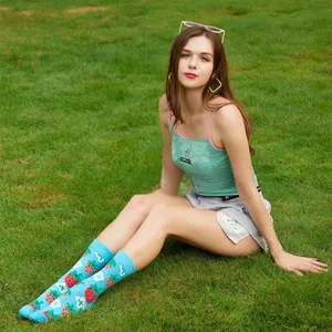 Detailed shot of bright blue mid-calf socks with cute strawberry and flower patterns.