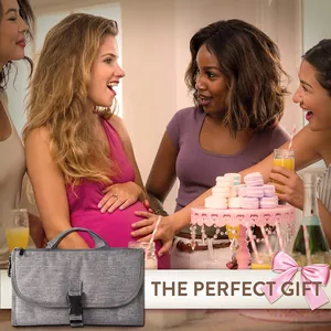Tapis à langer portable gris présenté comme cadeau dans une scène de baby shower
