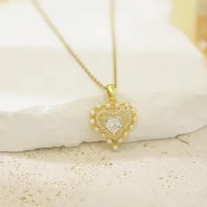 Elegant heart-shaped pendant necklace featuring pearls and crystals in a gold finish
