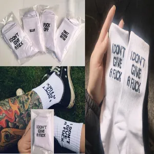 Macro view of white cotton crew socks featuring bold black English slogan text.