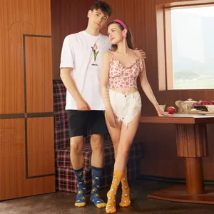 Detail view of couple wearing cute patterned mid-calf socks in a cozy indoor setting