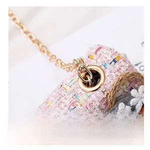 Close-up detail of durable gold metal hardware on children's pink tweed crossbody bag