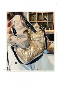 Gold quilted down cotton tote bag with wide black and white strap shown in detail
