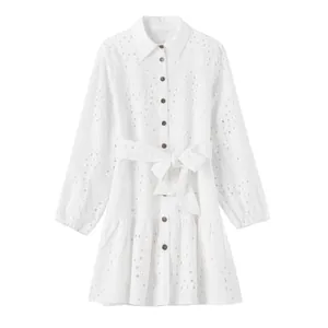 Détail de la robe chemise blanche à manches longues avec jupe à étages et broderies