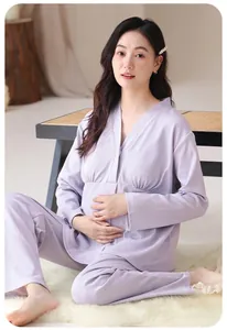 Pregnant woman in purple maternity pajamas set sitting on a white fuzzy rug
