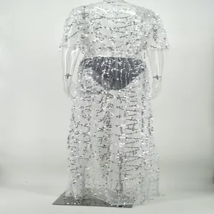 Détail montrant les paillettes argentées scintillantes sur le tissu de la robe chic.