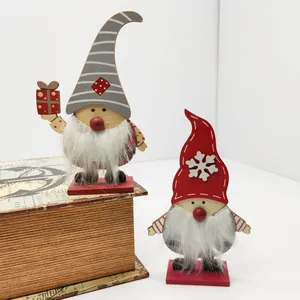 Pair of handcrafted wooden Christmas gnomes with faux fur beards on a vintage book.