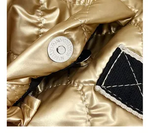 Close-up view of the secure magnetic snap closure on a metallic gold quilted tote bag