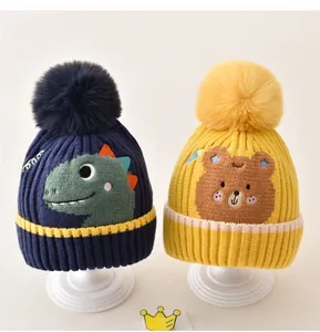 Detailansicht warmer Winter-Strickmützen mit sehr niedlichen Dino- und Bärenmotiven