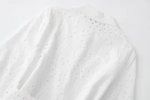 Vue détaillée de la broderie anglaise blanche sur la texture d'une robe chemise