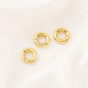 Détail de trois fermoirs ronds à ressort plaqués or 14K pour la création de bijoux.